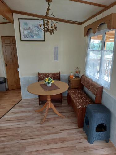 una sala de estar con una mesa y un sofá en Mobilní dům Rimini a Monaco v kempu ve Výrovicích, en Výrovice
