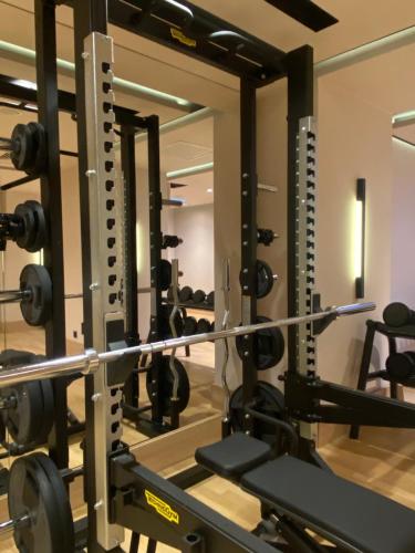 a gym with a row of squat racks with weights at Hotel Pieniny Grand Wellness & SPA - Destigo Hotels in Szczawnica