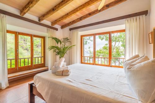 a bedroom with a large white bed with windows at Alconasser in Sóller