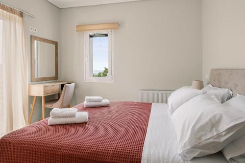 a bedroom with a large bed with towels on it at Vasilopoulos Residences - Apartments Eliana & Melanthia in Argostoli