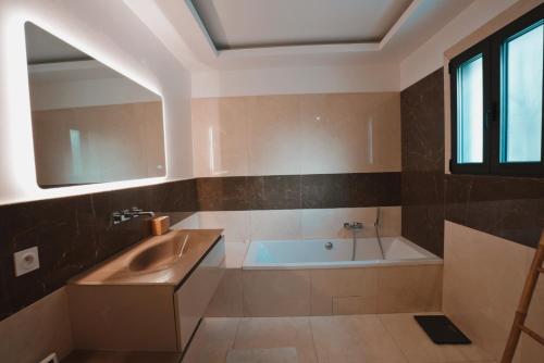 une salle de bain avec une baignoire et un lavabo dans l'établissement Modern Villa Swimming pool and private Jacuzzi, au Muy