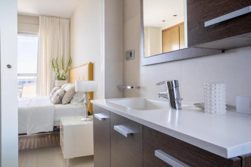 a bathroom with a sink and a bedroom with a bed at Apartamentos Vista Bella in Calpe