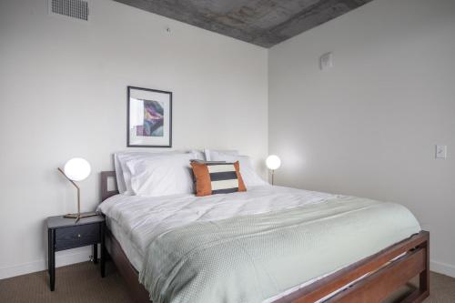 um quarto com uma cama com lençóis brancos e 2 candeeiros em Lower Nob Hill 2BR w Roofdeck BBQ nr Shops SFO-183 em São Francisco