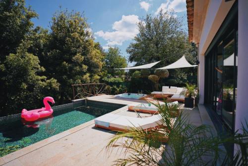 une piscine avec un flamingo rose dans une arrière-cour dans l'établissement Modern Villa Swimming pool and private Jacuzzi, au Muy