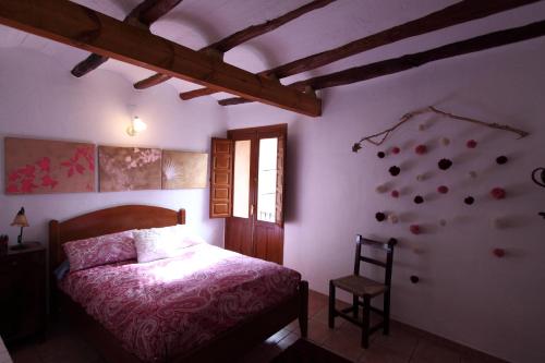 1 dormitorio con 1 cama y 1 silla en Casa Rural Cal Baté en Pratdip