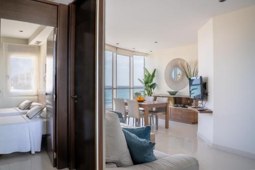 a living room with a couch and a dining room at Apartamentos Vista Bella in Calpe