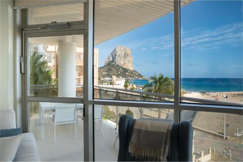 a room with a view of the beach and the ocean at Apartamentos Vista Bella in Calpe