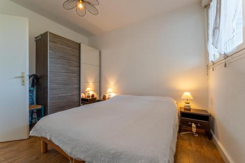 Un dormitorio con una gran cama blanca y una ventana en Le Chemin du bois - Proche station de ski en Saint-Laurent-en-Grandvaux