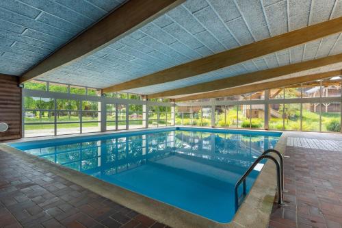 une piscine intérieure avec un grand plafond dans l'établissement Le Chemin du bois - Proche station de ski, à Saint-Laurent-en-Grandvaux