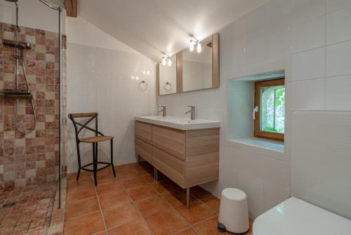 ein Bad mit einem Waschbecken und einer Dusche in der Unterkunft L'Airial, Moustey in Moustey