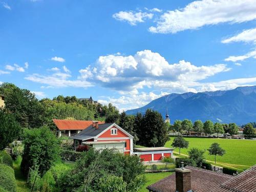 a house in a field with mountains in the background at Das Schmiedhofer in Bleiburg in Bleiburg