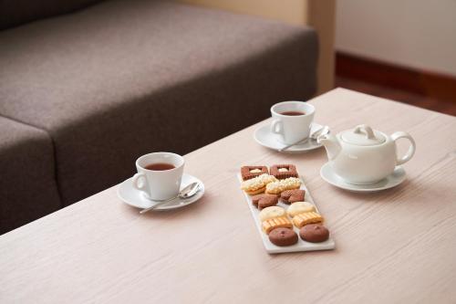 two cups of coffee and a tray of donuts on a table at UNA Hotels Bologna San Lazzaro in San Lazzaro di Savena