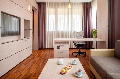 a living room with a couch and a table at UNA Hotels Bologna San Lazzaro in San Lazzaro di Savena