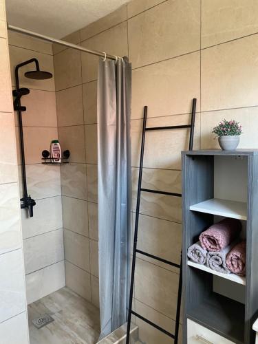 a shower with a shower curtain in a bathroom at Apartman Laura in Smoljanac