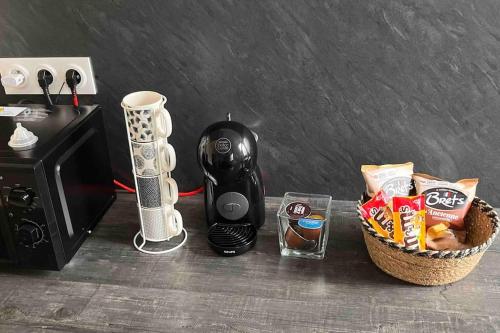 eine Kaffeemaschine und ein Korb mit Snacks neben einer Mikrowelle in der Unterkunft Appartement f2 Résidence Nassau in Beauvais