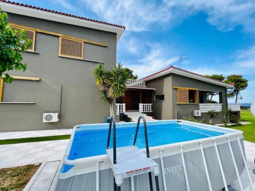 a swimming pool in front of a house at Gazonia Family Estate in Skala Kefalonias