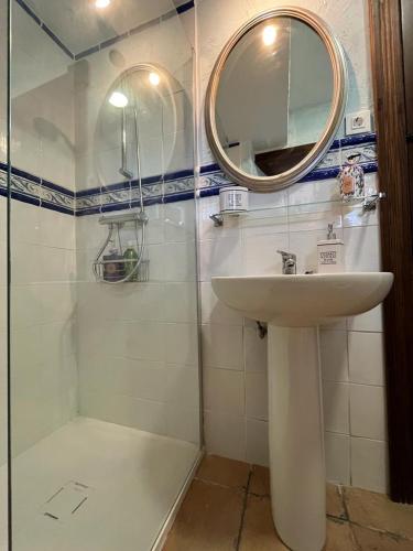 a bathroom with a sink and a shower with a mirror at Casa Rural La Ferrería in Vinuesa