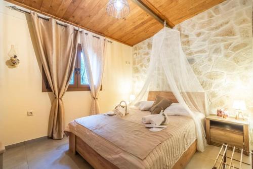 a bedroom with a bed with a mosquito net at Relaxing StoneHouse Kamara with Jacuzzi in Pómbia