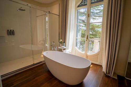 a white bath tub in a bathroom with a window at Torre del Remei in Bolvir