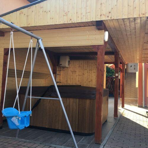 a building with a porch with a blue bucket under it at Sweet Home Apartman in Hajdúszoboszló