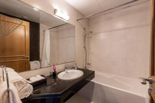 La salle de bains est pourvue d'un lavabo et d'une baignoire. dans l'établissement Supurb 2 Bed Room Apt Sea Front (Side View), à Abu Dhabi