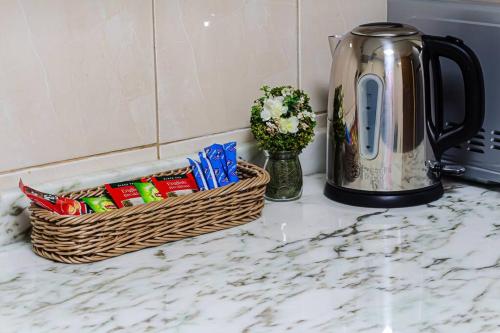 a kitchen counter with a basket of snacks next to a tea kettle at Supurb 2 Bed Room Apt Sea Front (Side View) in Abu Dhabi