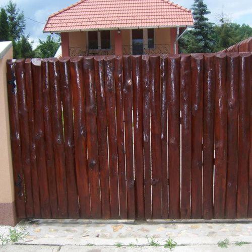 a wooden fence in front of a house at Sweet Home Apartman in Hajdúszoboszló