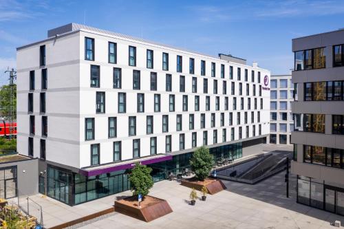 a large white building with trees in front of it at Premier Inn Freiburg City Süd in Freiburg im Breisgau
