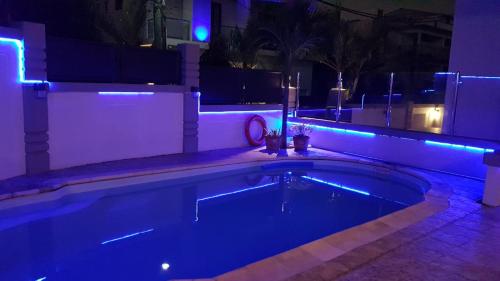 a swimming pool lit up at night with blue lights at Monalysa St Honore Apartment & Studios Grand Bay in Grand Baie