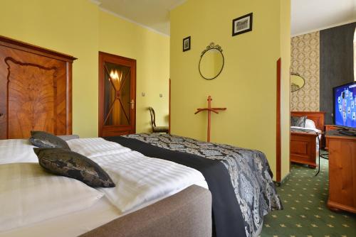 a hotel room with a bed and a tv at City Hotel Morris in Česká Lípa