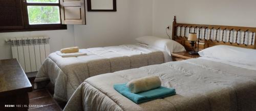 a room with two beds with towels on them at Albergue el Caseron de Fuentes Carrionas in Cardaño de Abajo