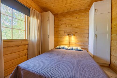 1 dormitorio con 1 cama en una habitación con ventana en Himos Huili 1, en Jämsä