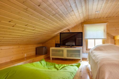 a bedroom with a bed and a flat screen tv at Himos Huili 1 in Jämsä