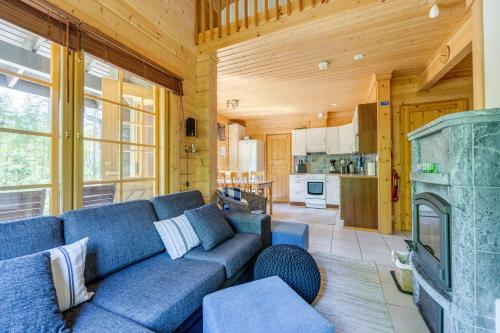 - un salon avec un canapé bleu et une cheminée dans l'établissement Himos Huili 1, à Jämsä