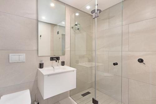 a bathroom with a sink and a glass shower at Casa on Quendon by Totalstay in Cape Town