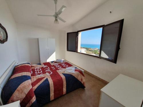een slaapkamer met een bed en een groot raam bij Villa Zina, una terrazza sul mediterraneo. in Agrigento