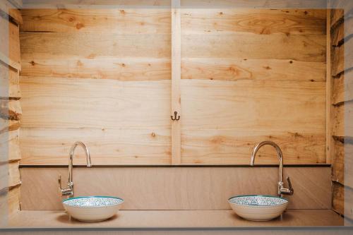 La salle de bains est pourvue de deux lavabos et de deux robinets. dans l'établissement Ty Llewelyn Glamping & Camping, à Llanidloes