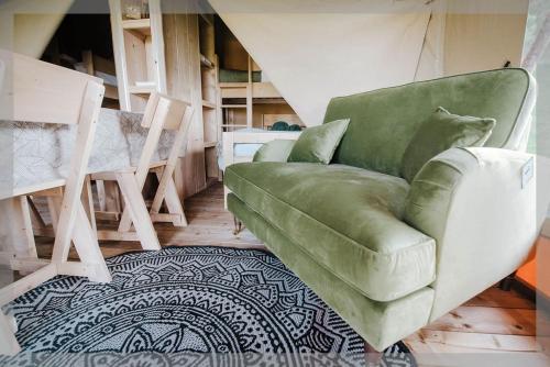 a living room with a green chair and a rug at Ty Llewelyn Glamping & Camping in Llanidloes