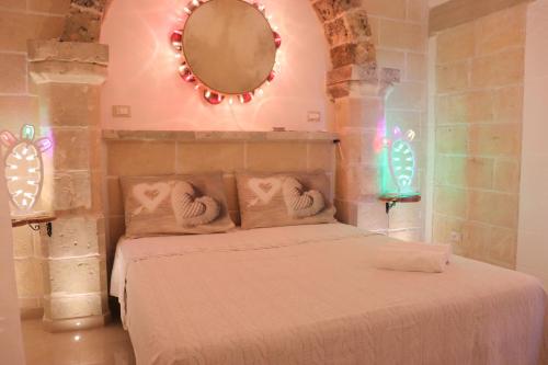 Dormitorio con cama con espejo y luces en B&B Lu Core Nosciu, en Aradeo