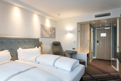 a bedroom with a large white bed and a desk at Premier Inn Freiburg City Süd in Freiburg im Breisgau