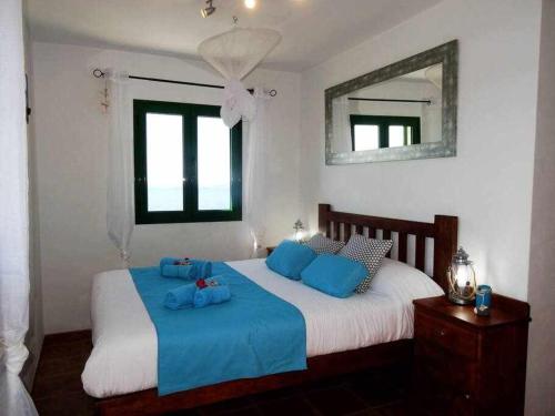 a bedroom with two beds with blue pillows and a mirror at Apartamento Vacacional Pescaito en Playa Quemada in Playa Quemada