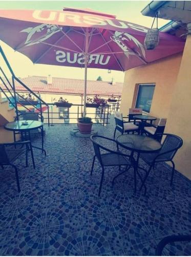a restaurant with tables and chairs and an umbrella at Pensiunea Pelican in Tulcea