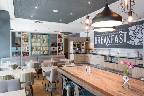 a restaurant with a large bar with tables and chairs at Premier Inn Freiburg City Süd in Freiburg im Breisgau
