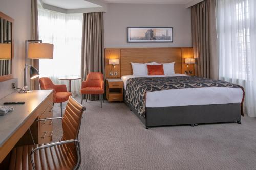 a hotel room with a bed and a desk at The Crown London, WorldHotels Distinctive in London