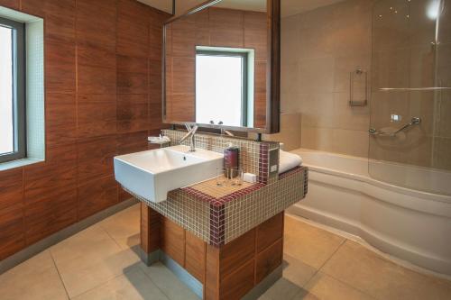 a bathroom with a sink and a shower and a tub at The Crown London, WorldHotels Distinctive in London