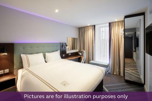 a hotel room with a bed and a bathroom at Premier Inn Freiburg City Süd in Freiburg im Breisgau