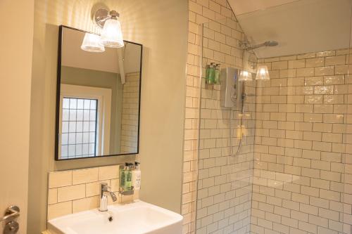 ein Bad mit einem Waschbecken und einem Spiegel in der Unterkunft Duke of York in Whitby