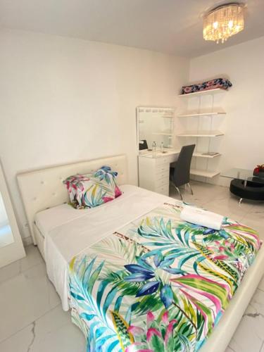sypialnia z łóżkiem z kolorowym kocem w obiekcie Agréable chambre w mieście Menucourt
