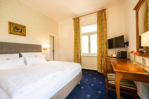 a hotel room with a bed and a desk at Historische Spitzgrundmühle in Coswig