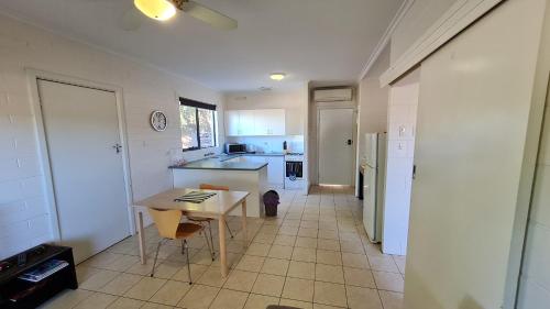 a kitchen with a table and a table and chairs at Stay Awhile in Port Pirie - min stay 4 nights in Port Pirie